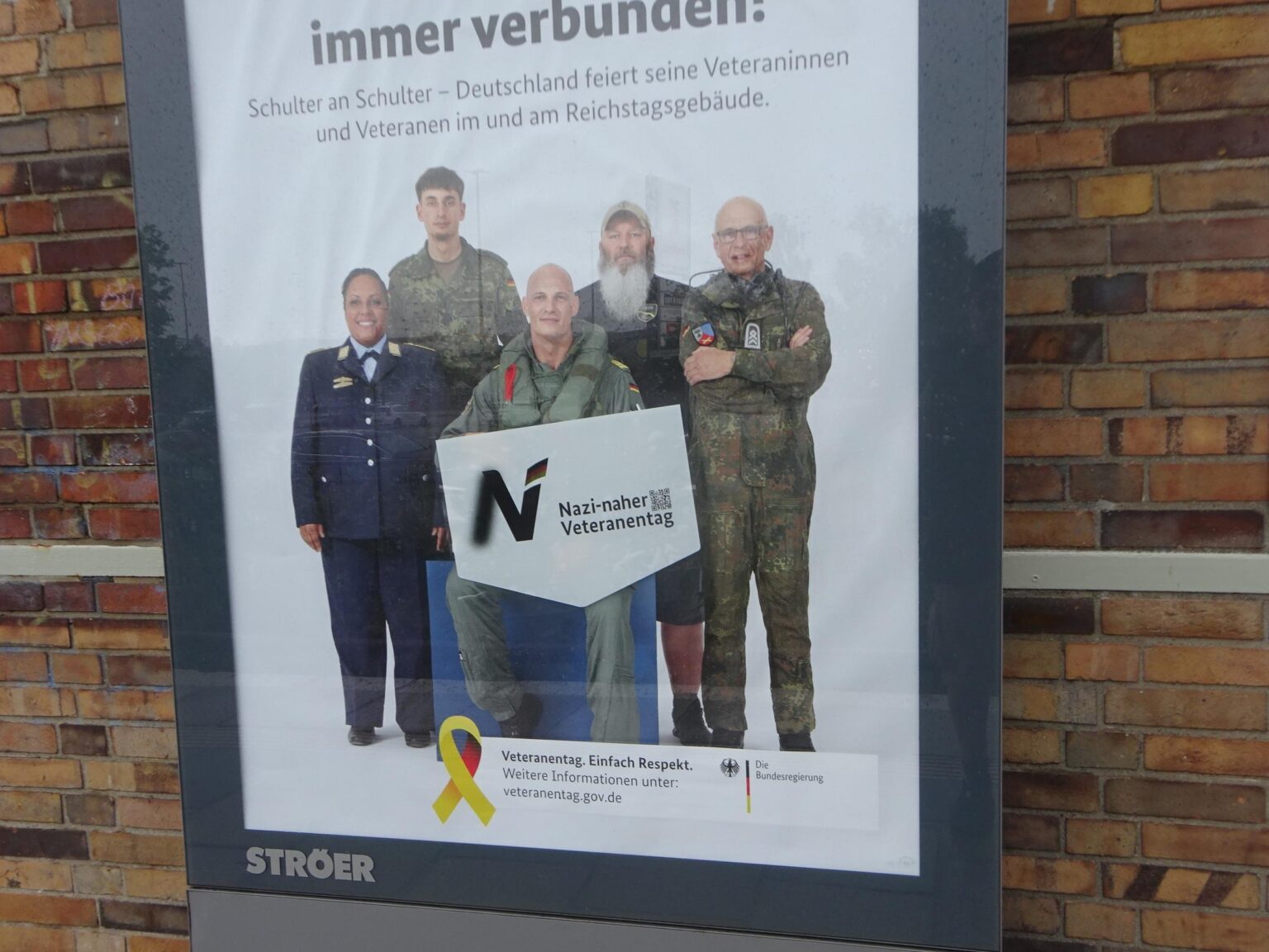 Adbusting-Aufkleber gegen Veteranentag-Werbung